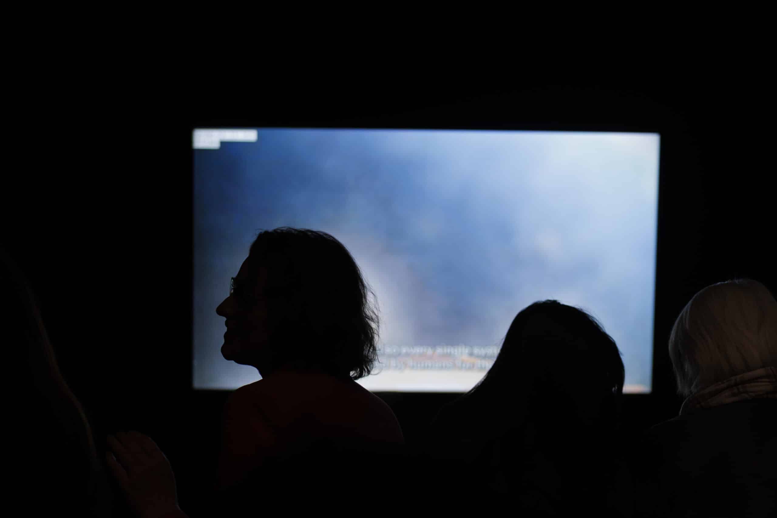 Visitors watch a video about the Artemis II expedition.